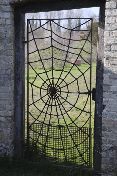 Fabulous wrought iron spiders web gate, with spider in the middle.
 #ironwebgate #spidersgate #webgate #gatesculpture #webwrought