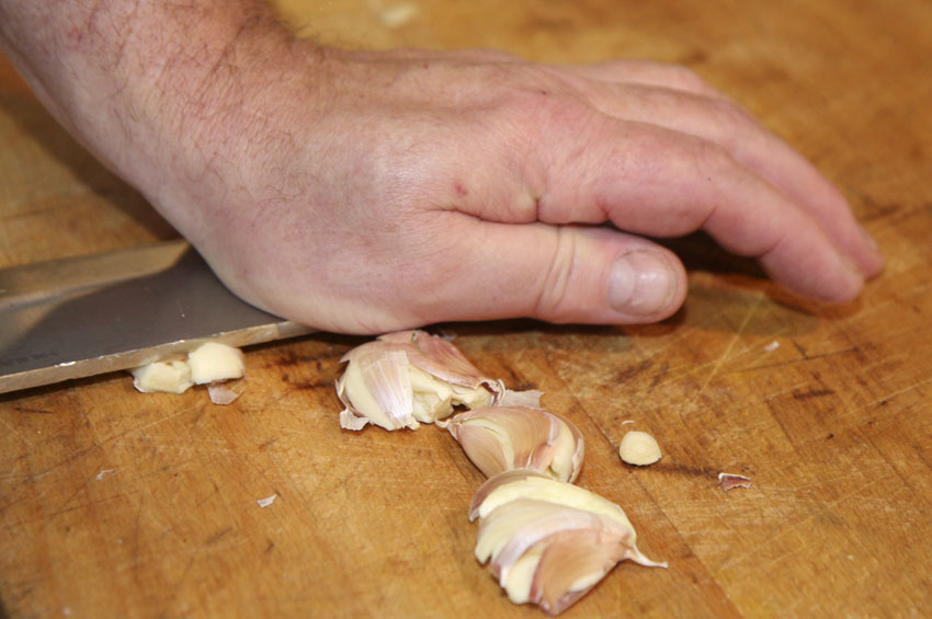Crush the garlic clove with the flat of a knife.jpg. Crush the garlic clove with the flat of a knife.jpg.