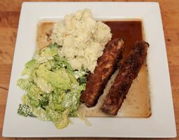 Breaded belly of pork fingers with creamy cabbage and red wine jus
