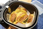 Filled taco shells stood in the air fryer