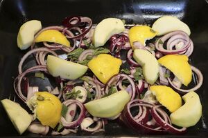 Onion slices, apple slices and herbs make a good bed for the pork