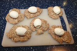 Press the sausage meat out into round-ish patties and place the eggs in the middle